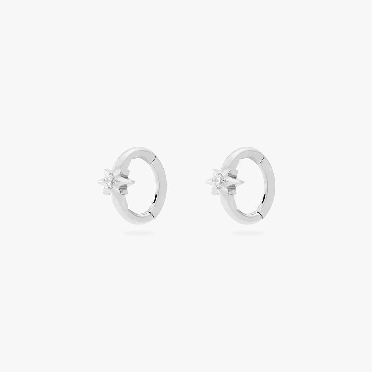 This is an image of a pair of silver-toned titanium clickers with twinkle-star shapes that feature crystal CZs in the center. These clickers are 6mm in diameter.