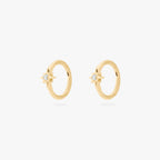 A pair of gold hoop earrings, each with a small star-shaped stone, against a white background.