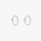 A pair of silver hoop earrings, each with a small star-shaped stone, against a white background.