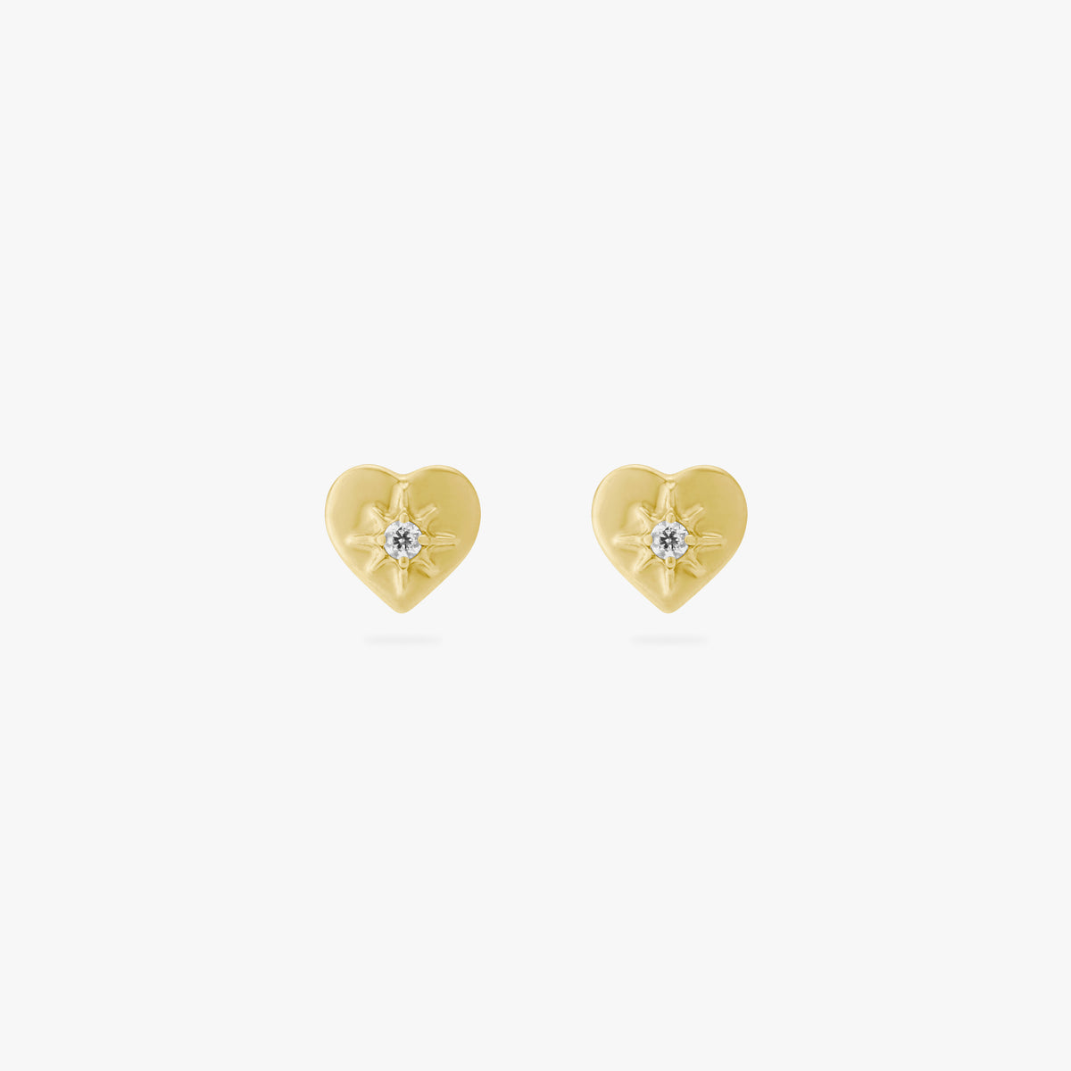 This is an image of a pair of gold-toned titanium flatback studs in the shape of hearts with twinkle shaped stars within them, and crystal CZs within that. 