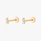 This is an image of a pair of gold-toned titanium flatback studs with 3 micro baguette cut stones placed in a cluster.
