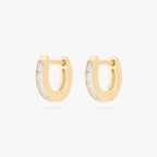 This is an image of a pair of 14K gold plated huggie earrings with 4 baguette cut, bezel set crystal CZs along the edge. 