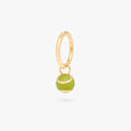 This image shows a green tennis ball charm on a gold clicker 