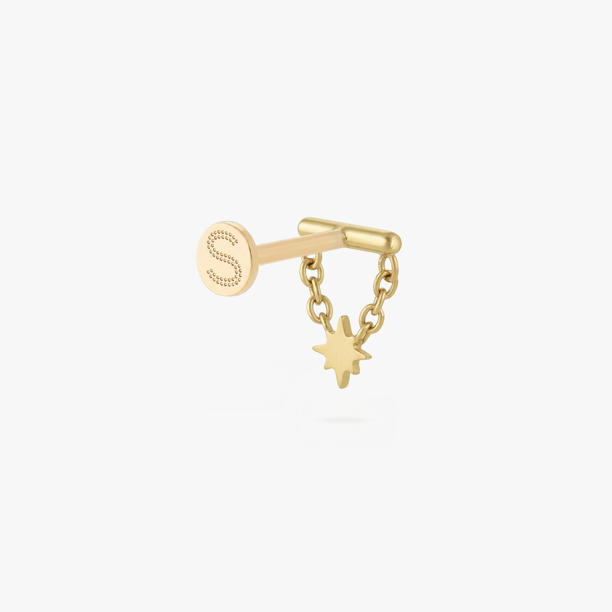 This is an image of a gold toned flatback stud which has a bar with chains from either side supporting a dangling twinkle star with a clear, round CZ center stone. 