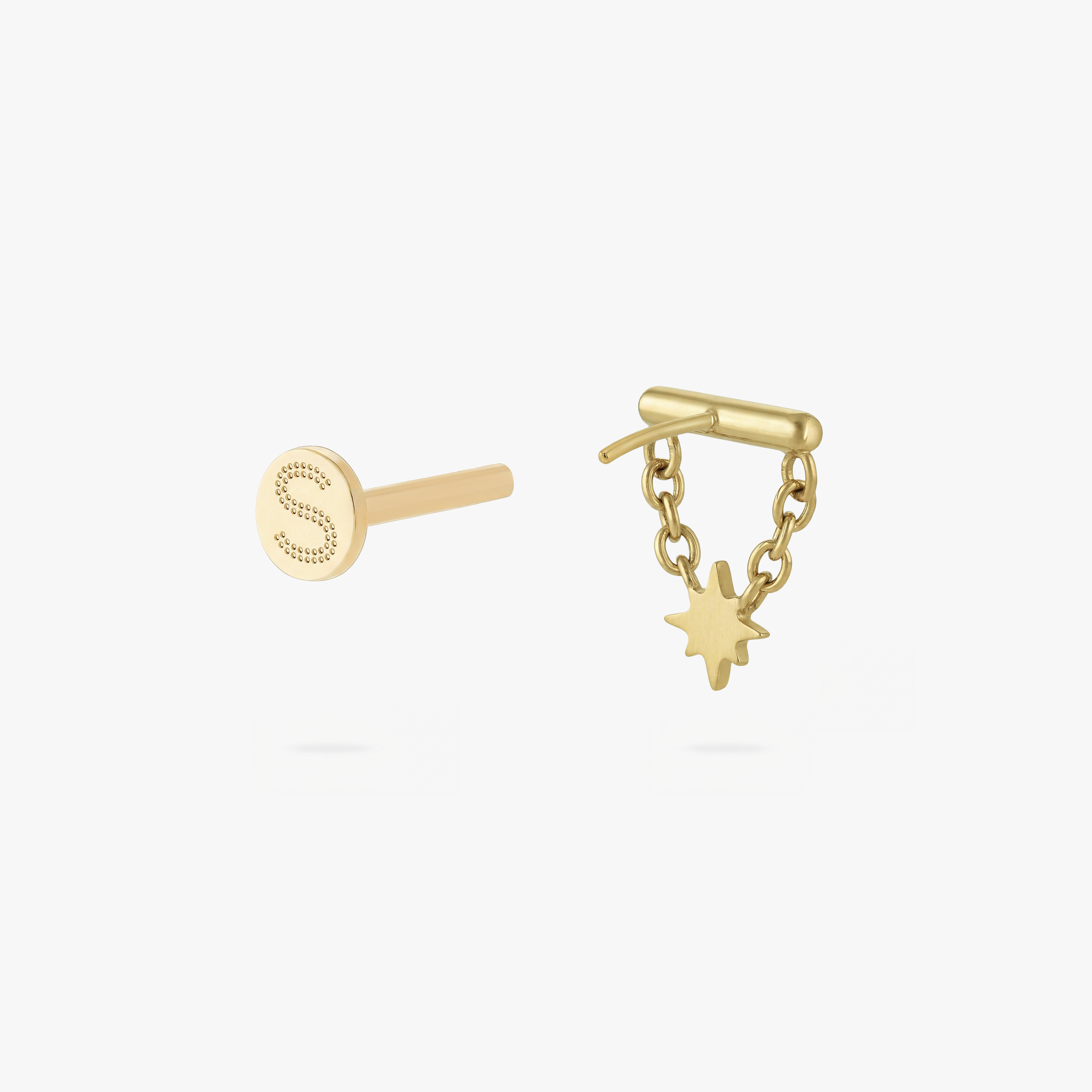 This is an image of a gold toned flatback stud which has a bar with chains from either side supporting a dangling twinkle star with a clear, round CZ center stone.