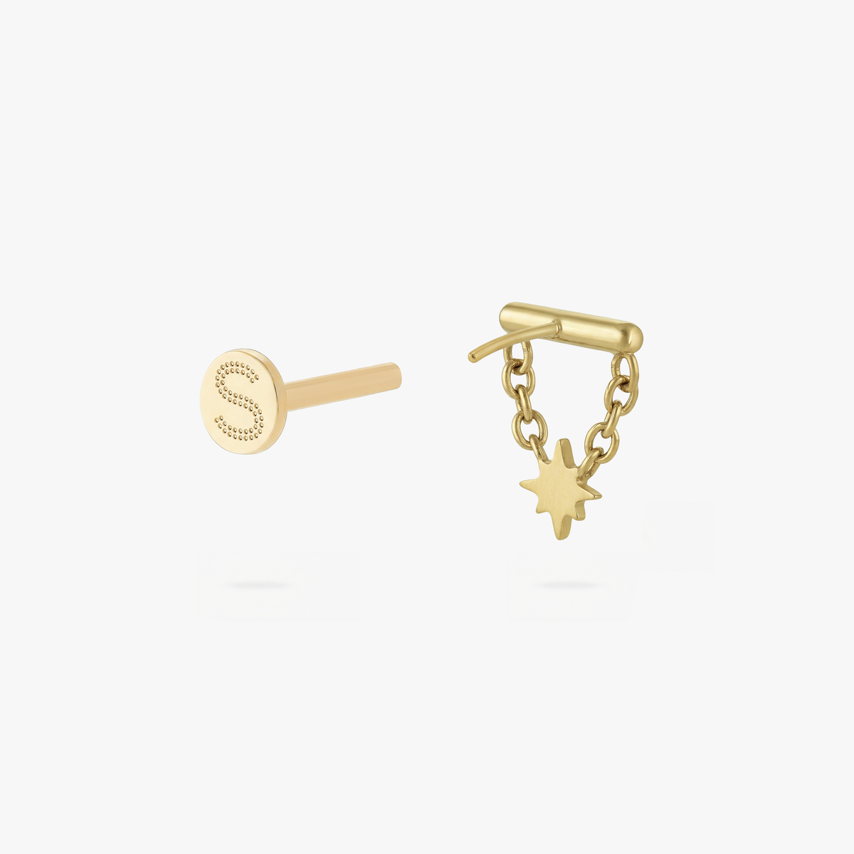 This is an image of a gold toned flatback stud which has a bar with chains from either side supporting a dangling twinkle star with a clear, round CZ center stone. 