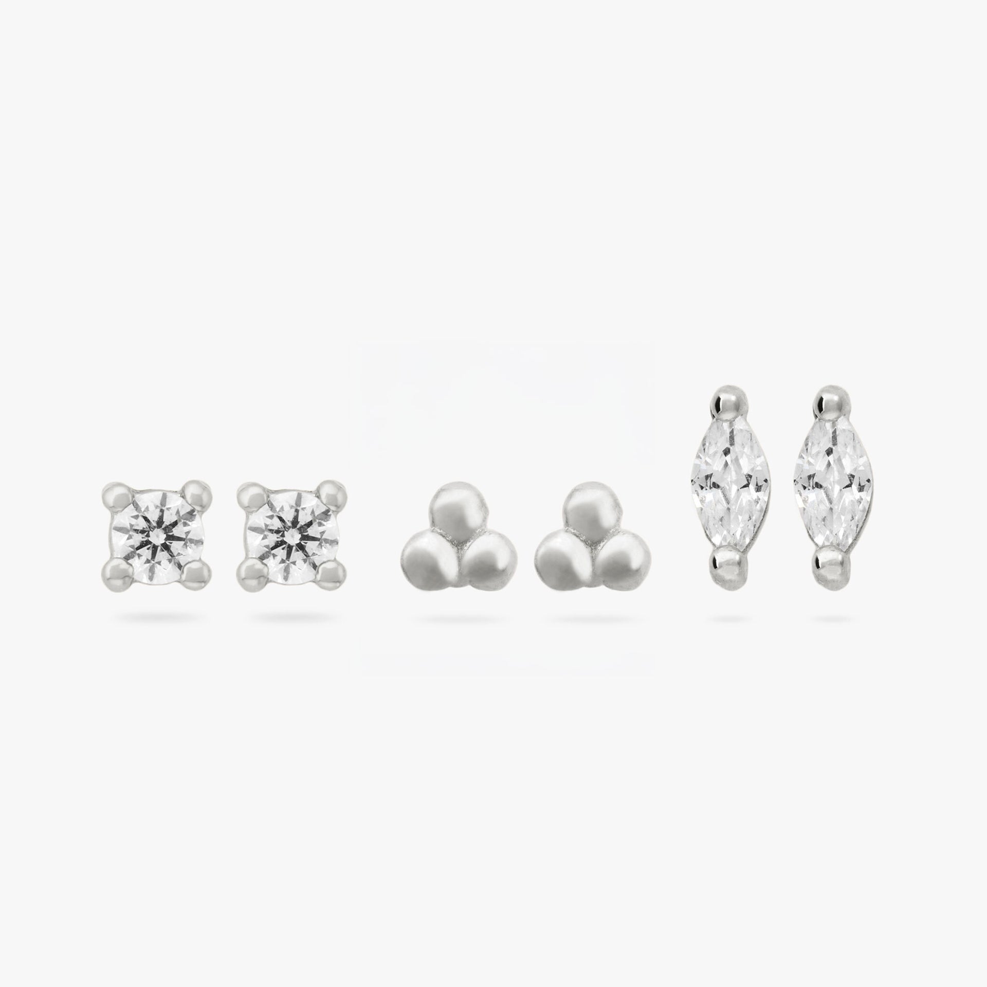 This image shows a set of three pair of  silver plated flatback studs. The set contains a clear cz stone stud, a trinity ball stud and a marquise stud with a clear cz stone. - Main view