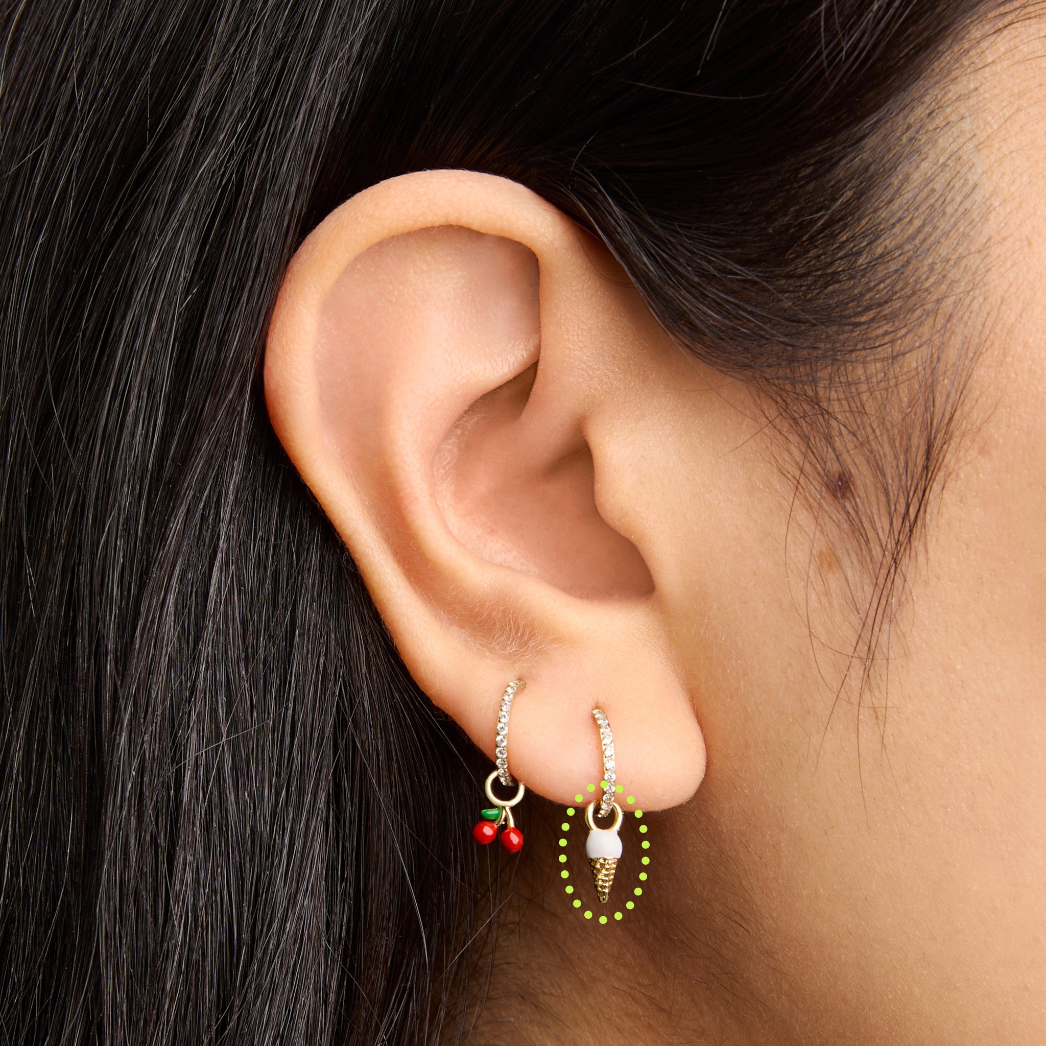 This is an image of a gold earring charm in the shape of an ice cream cone with white and tan enameling on ear. - Alternative view 2