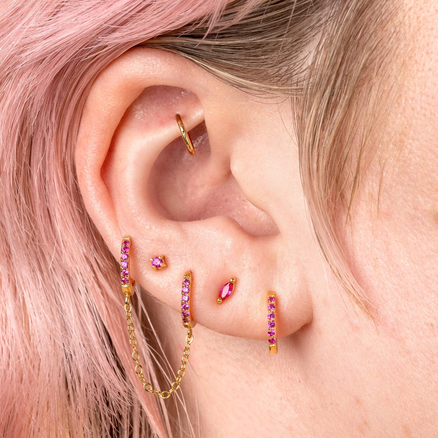 The marquise mini stud features a pink oblong shaped gem and has gold accents. [hover] color:gold/pink