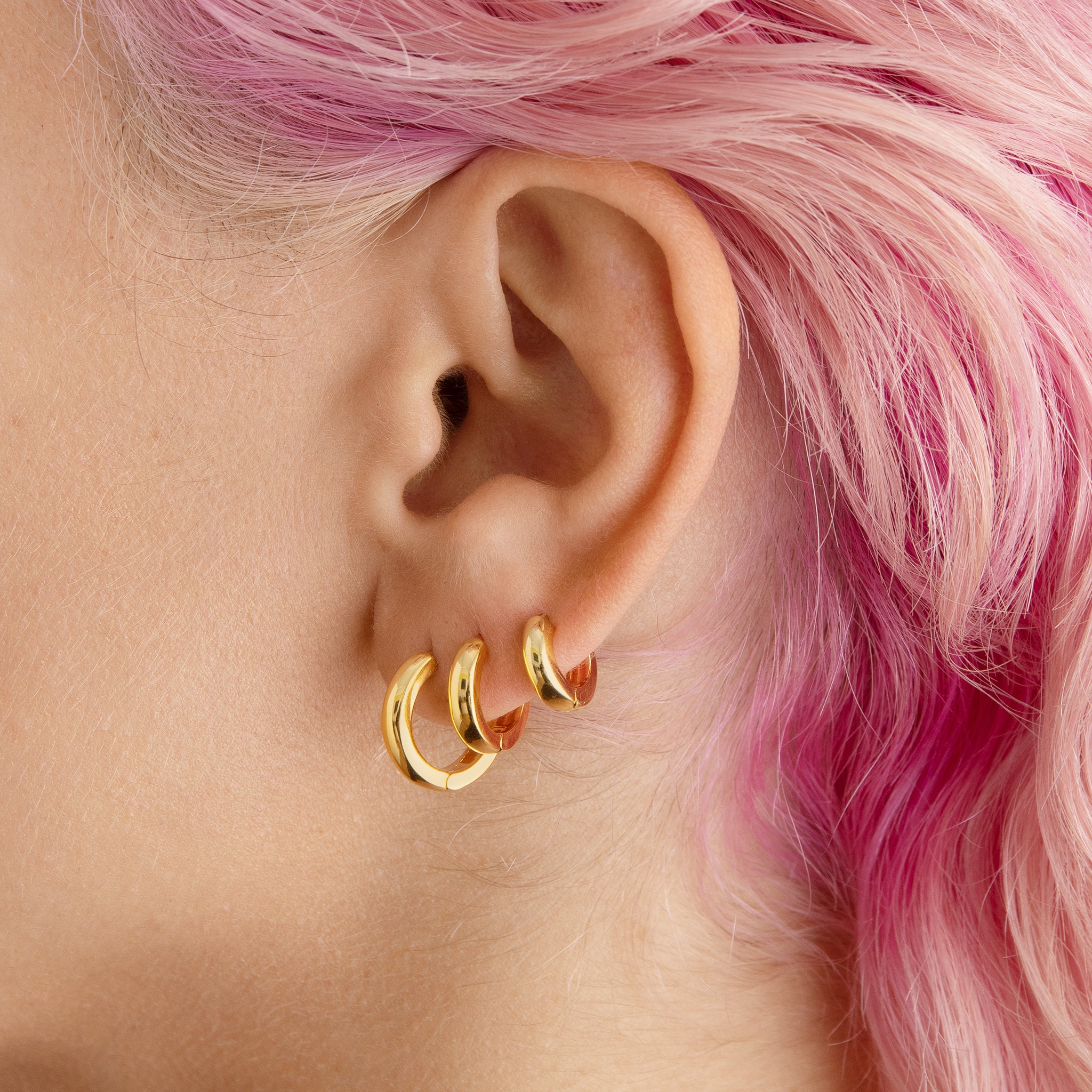 A set of chunky hoops containing a pair of micro gold chunky huggies, mini gold chunky huggies, and small gold chunky huggies [hover] color:null|gold