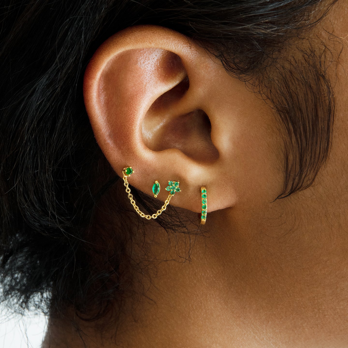 The marquise mini stud features a green oblong shaped gem and has gold accents. [hover] color:null|gold/green