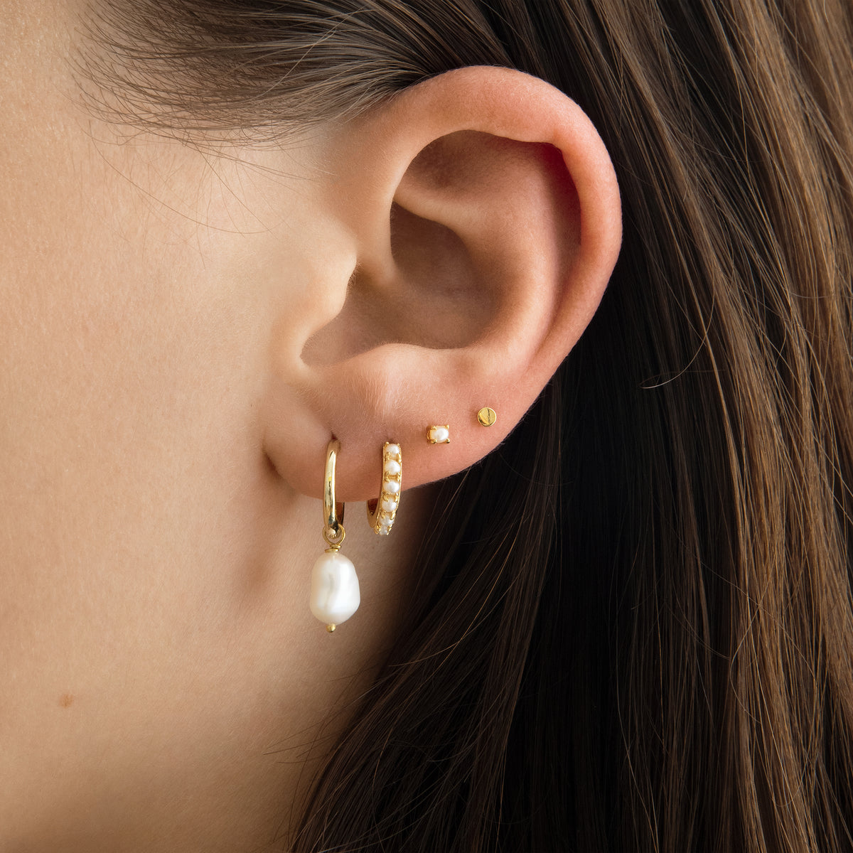 This is a dangling pearl huggie. [hover] color:null|gold
