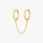 Two separate hoop earrings connected by a chain. color:null|gold