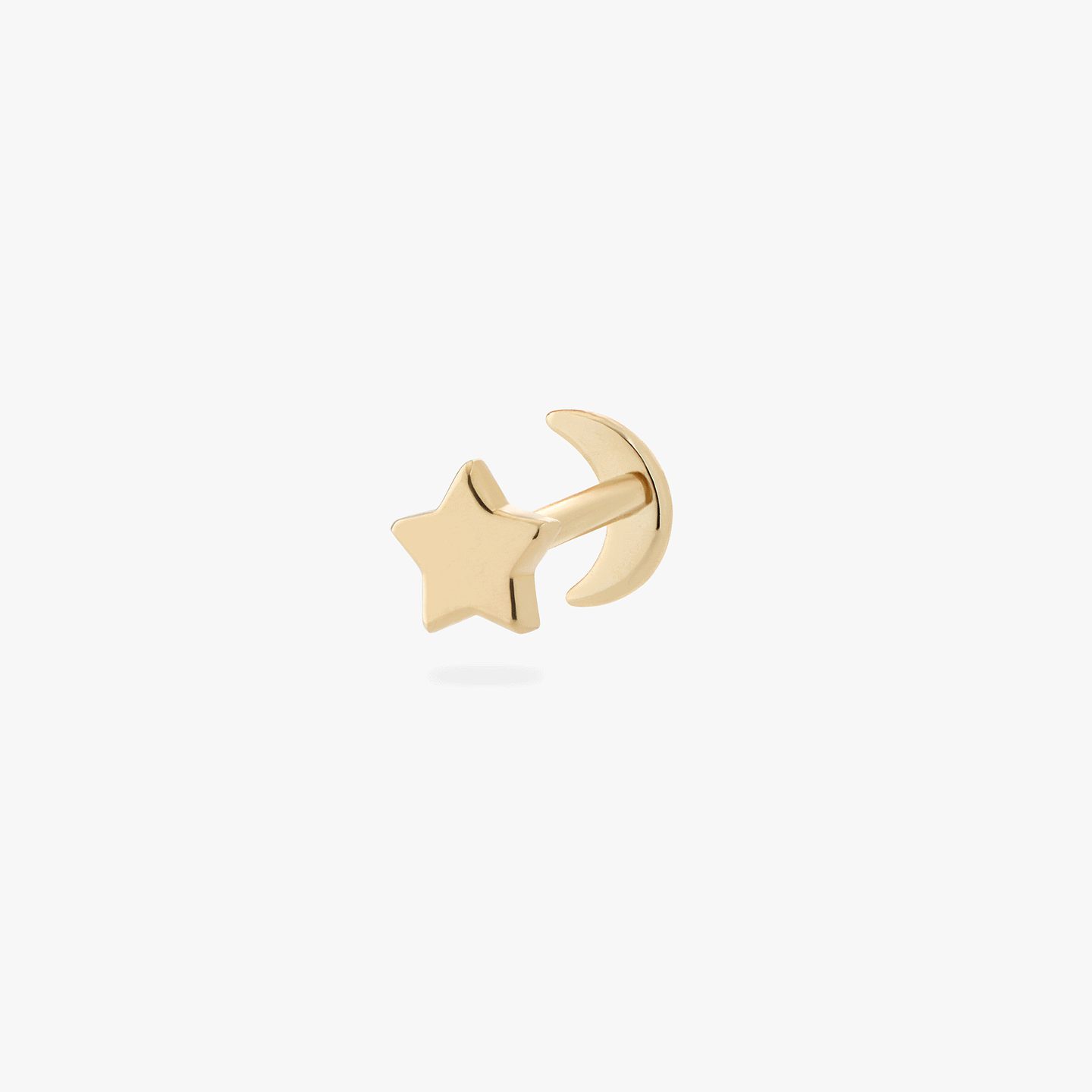 a gold labret with a star shaped disc with a moon shaped gold flatback top that works to be reversible color:null|gold