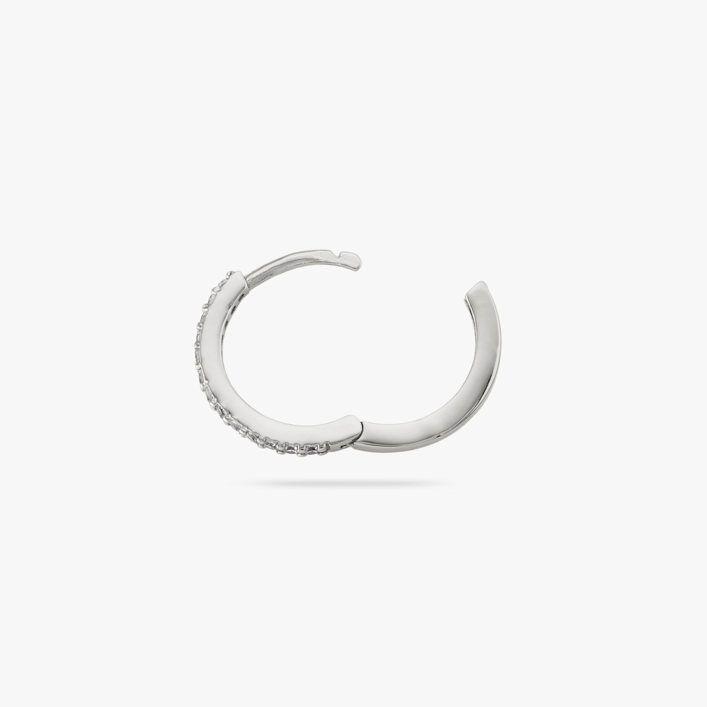 This is a small silver hoop with clear cz gems along the front and the clasp undone color:null|silver/clear