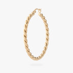 a large gold slim twisted hoop earring 