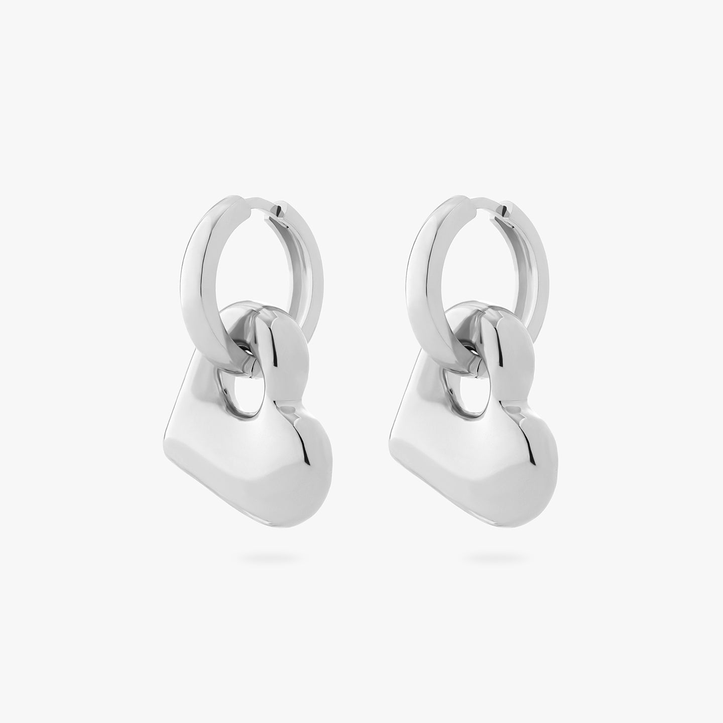a pair of chunky silver hoops that have a silver puffy heart as a charm on them [pair] color:null|silver
