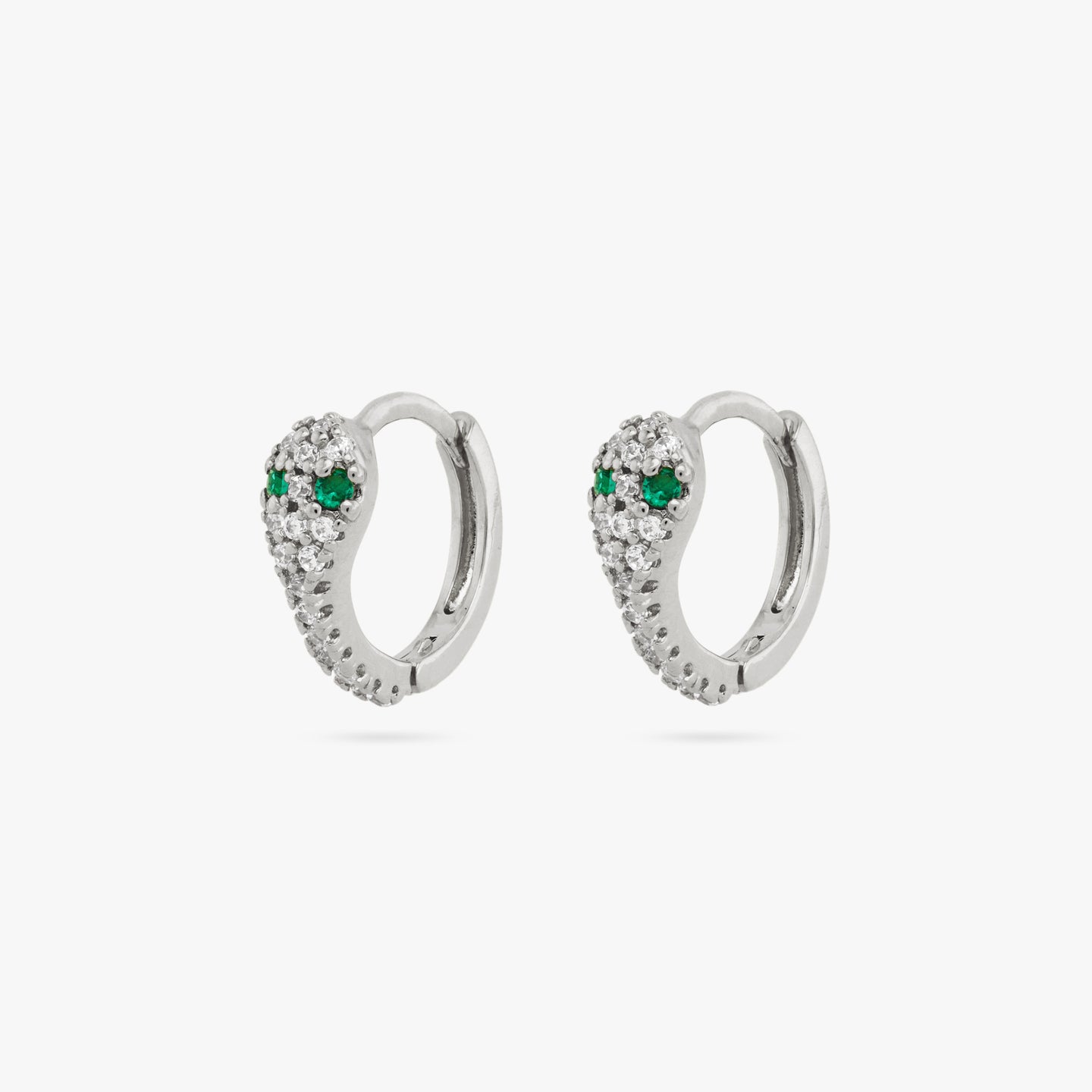 A pair of silver pave gem lined serpent shaped huggies with green CZ eyes. [pair] color:null|silver/clear