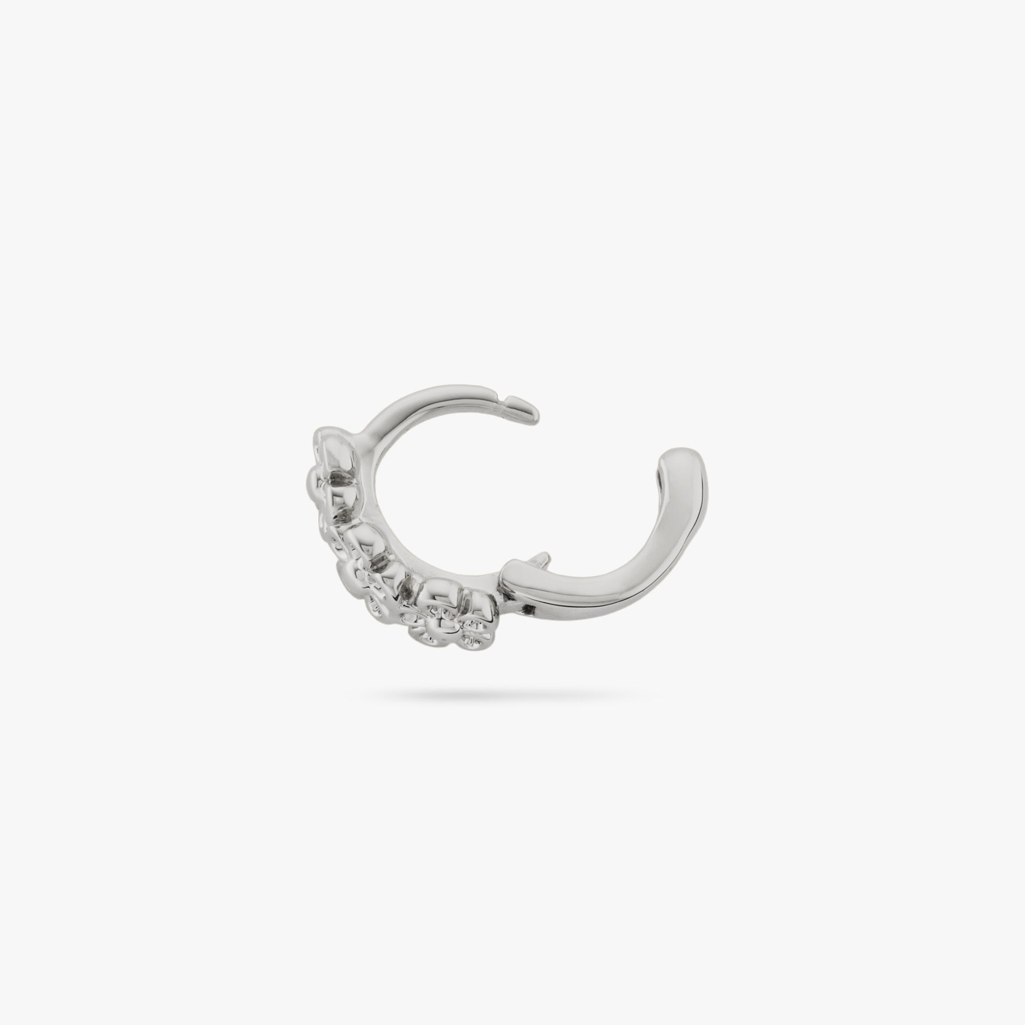 This is a micro huggie with three small silver daisy-shaped flowers color:null|silver