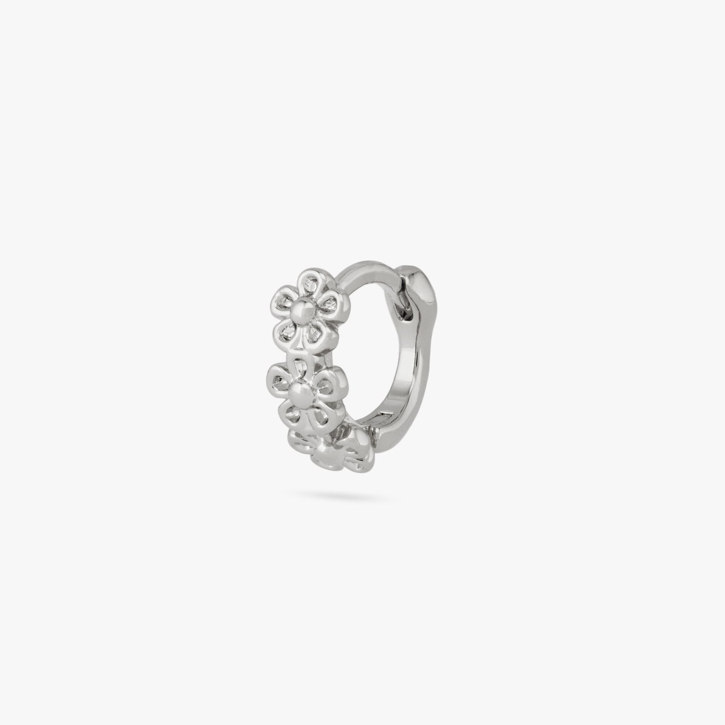 This is a micro huggie with three small silver daisy-shaped flowers color:null|silver