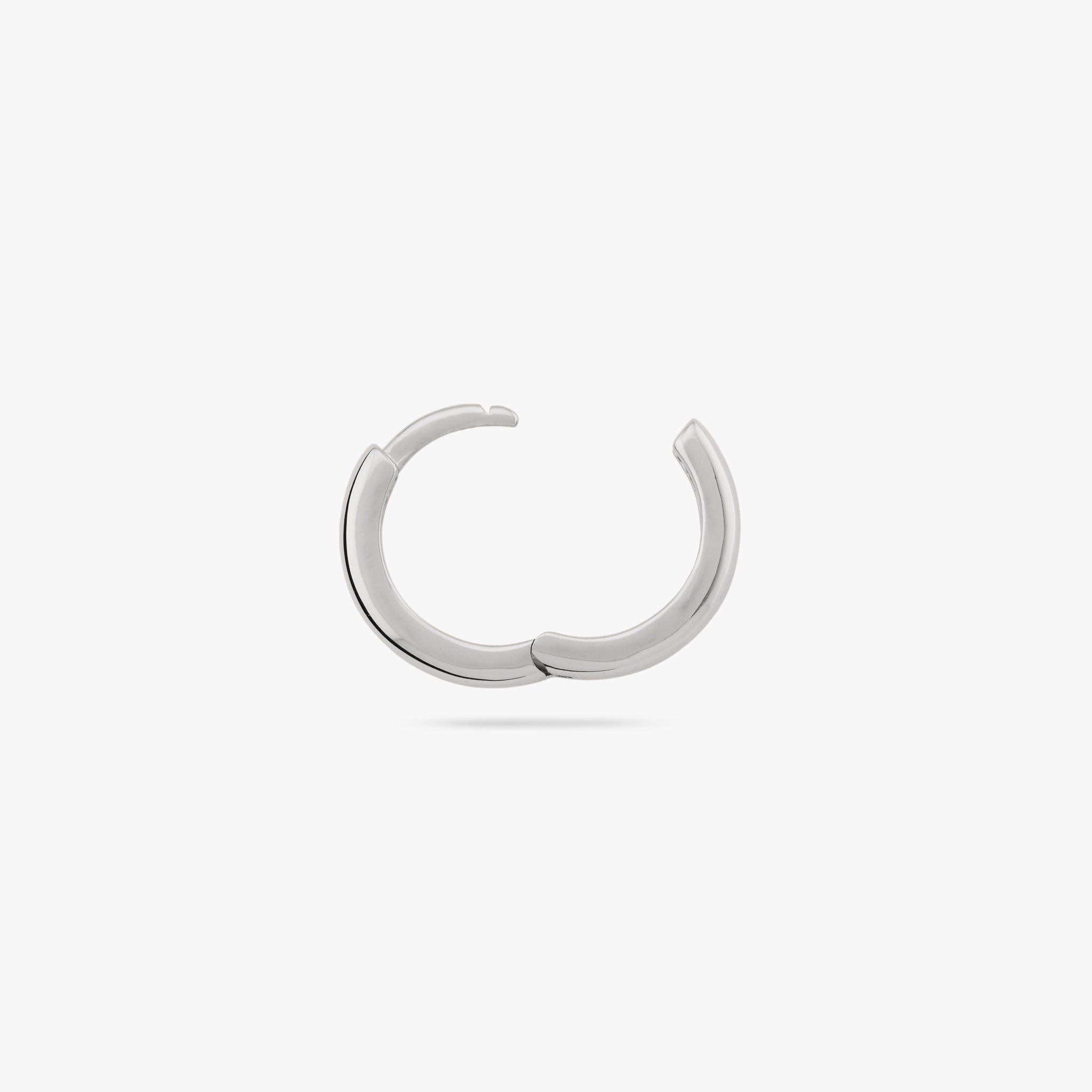 A small bulky and chunky shaped silver huggie and the clasp is undone color:null|silver
