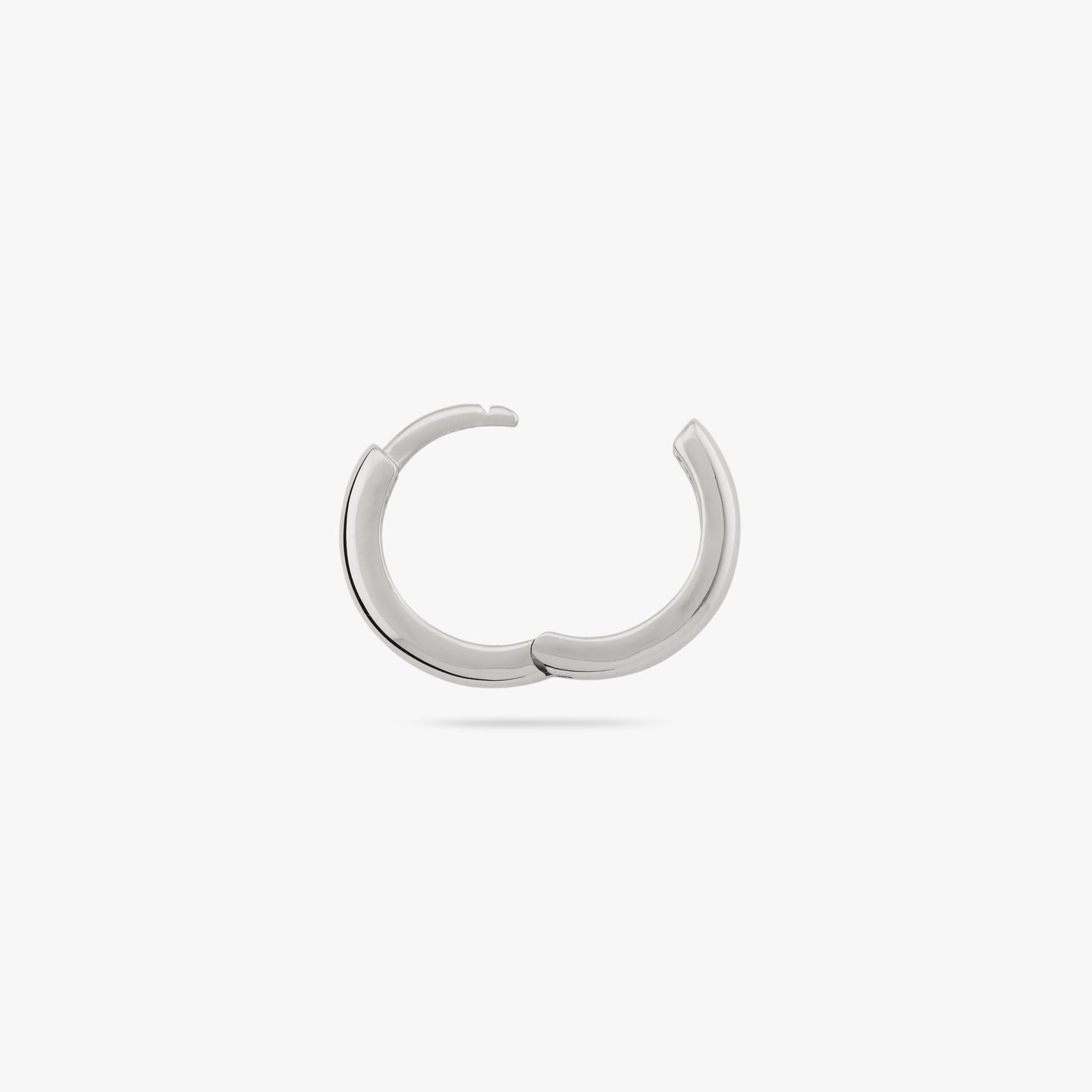A small bulky and chunky shaped silver huggie and the clasp is undone color:null|silver