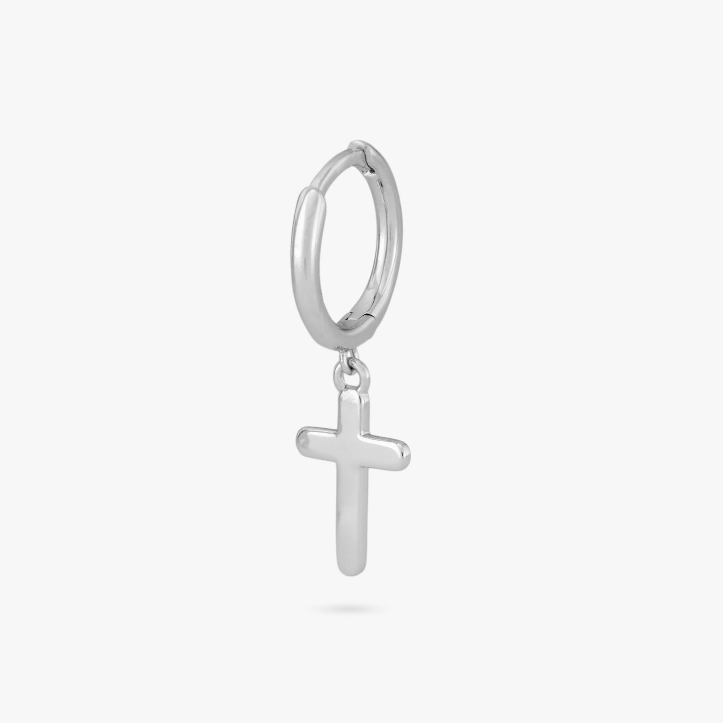 This is a small silver huggie with a cross charm dangle color:null|silver