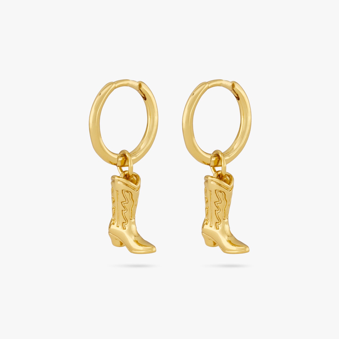 This is a pair of gold cowboy boot charms dangling from gold huggies [pair] color:null|gold