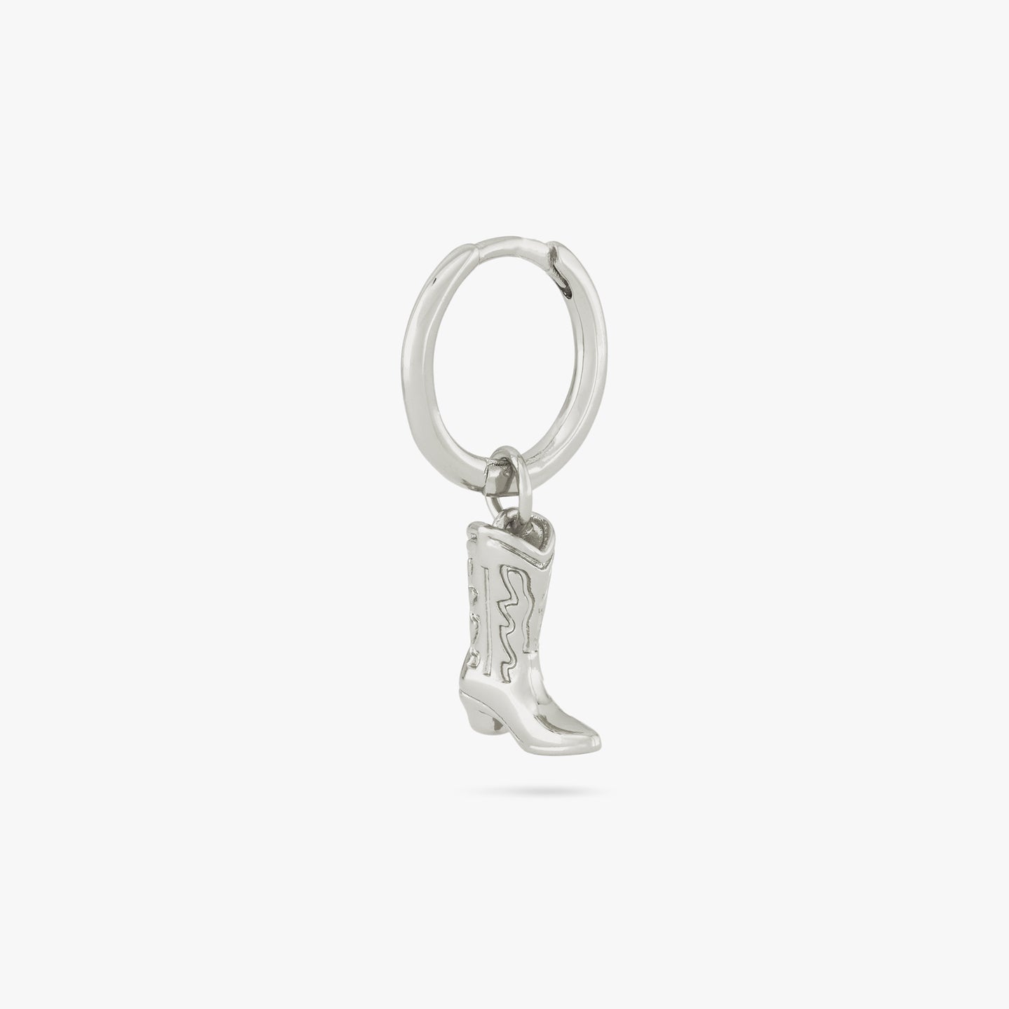 This is a silver cowboy boot charm dangling from a silver huggie color:null|silver
