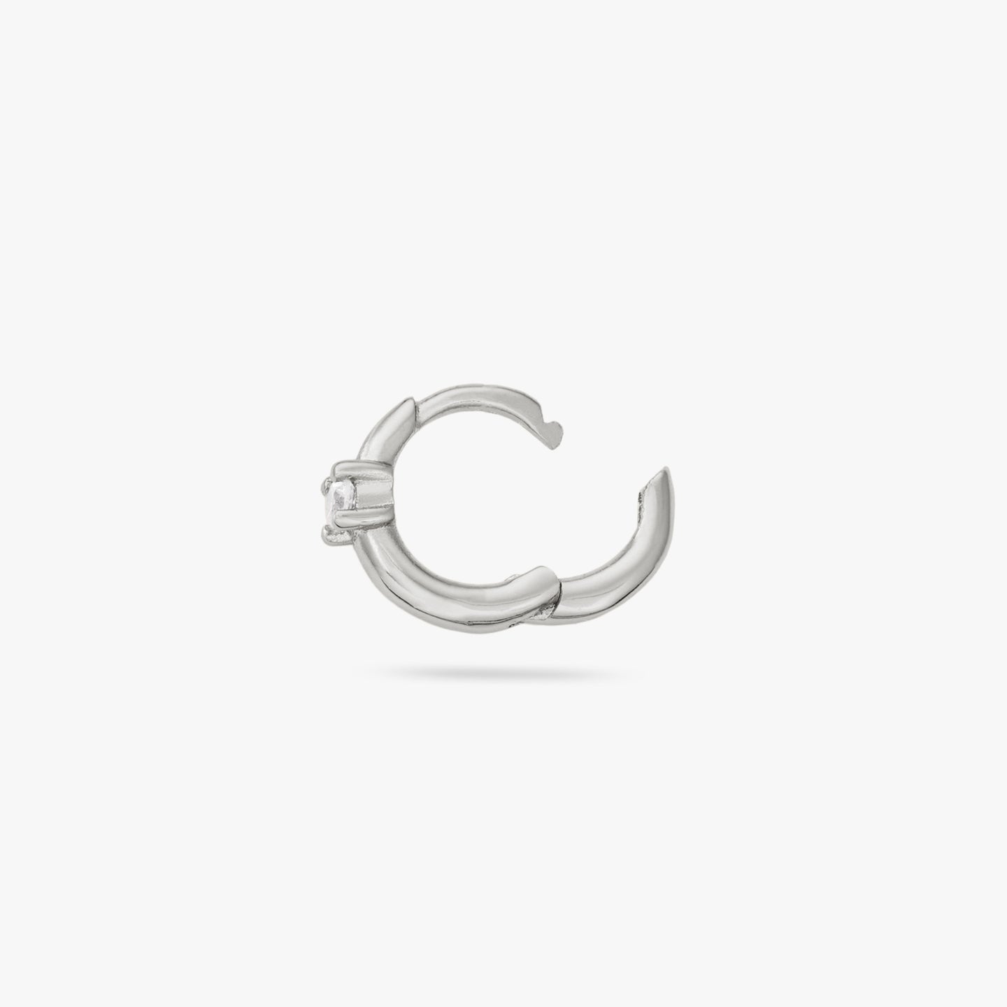This is a small silver huggie with a clear cz detail color:null|silver/clear
