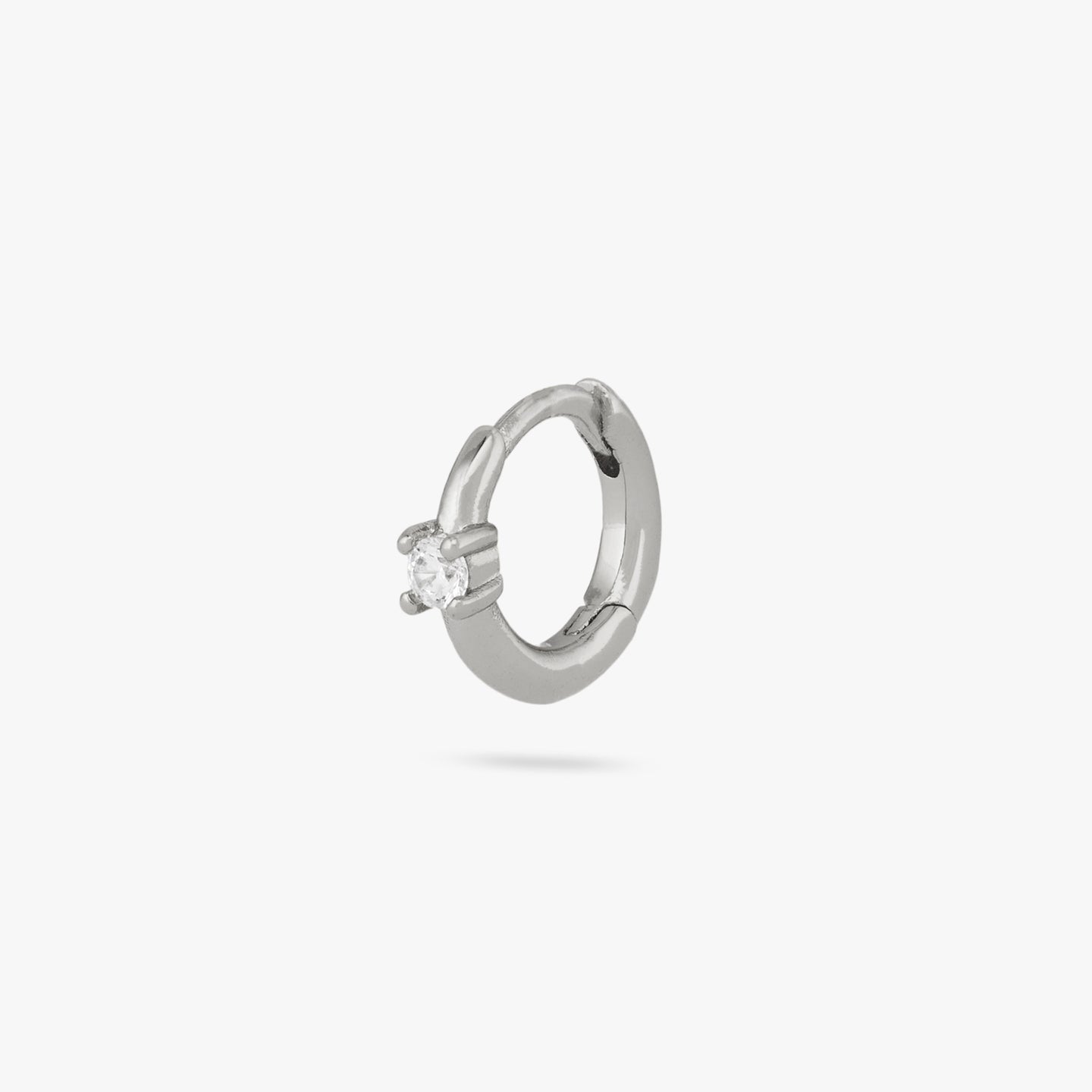 This is a small silver huggie with a clear cz detail color:null|silver/clear