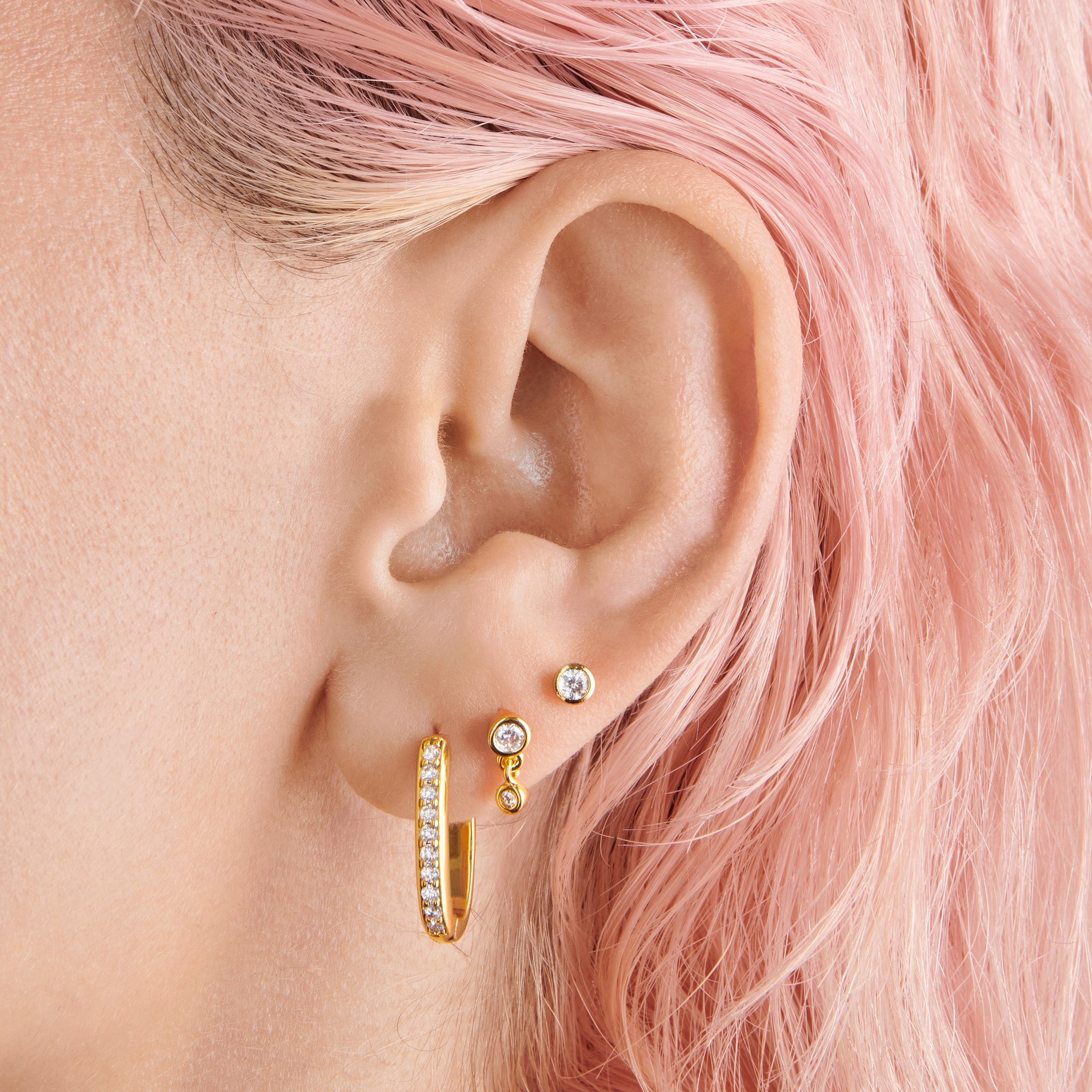 a gold medium oval hoop that has one side pave on ear [hover] color:null|gold/clear