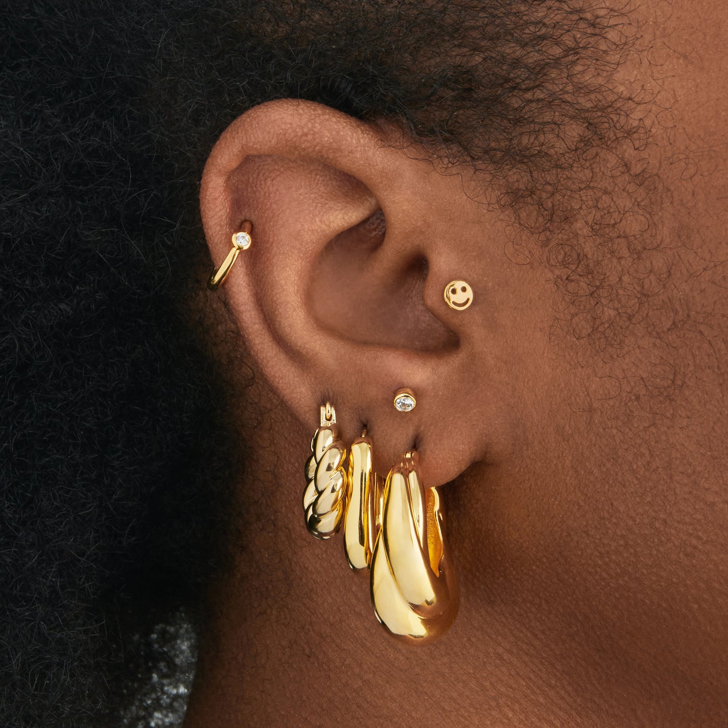 a large chunky hoop that twists and is gold on ear [hover] color:null|gold