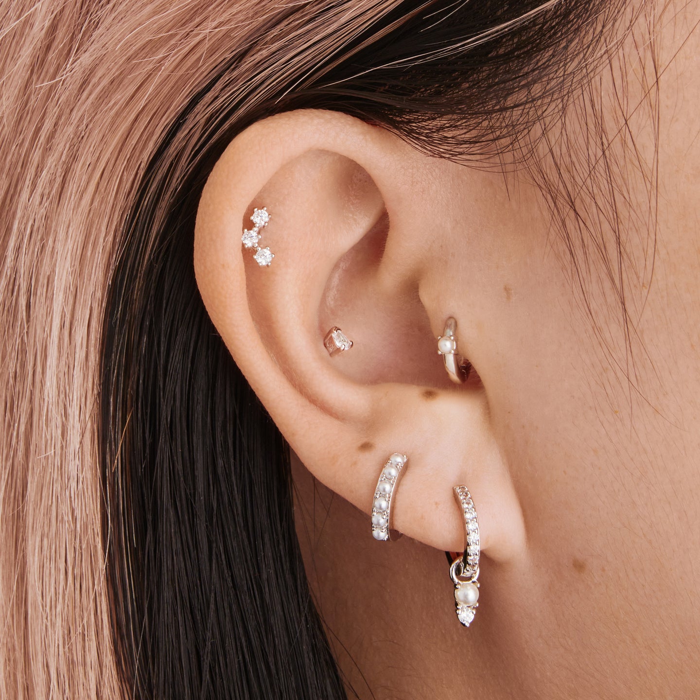 a silver small huggie with a pearl accent stone on ear [hover] color:null|silver