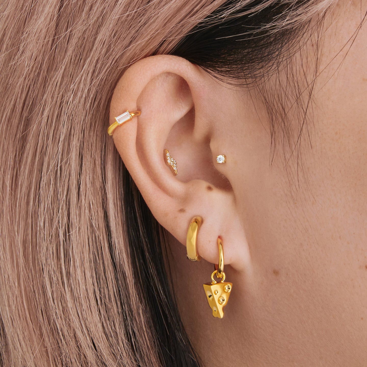 a gold small slim huggie with a gold charm shaped like a piece of cheese on ear [hover] color:null|gold