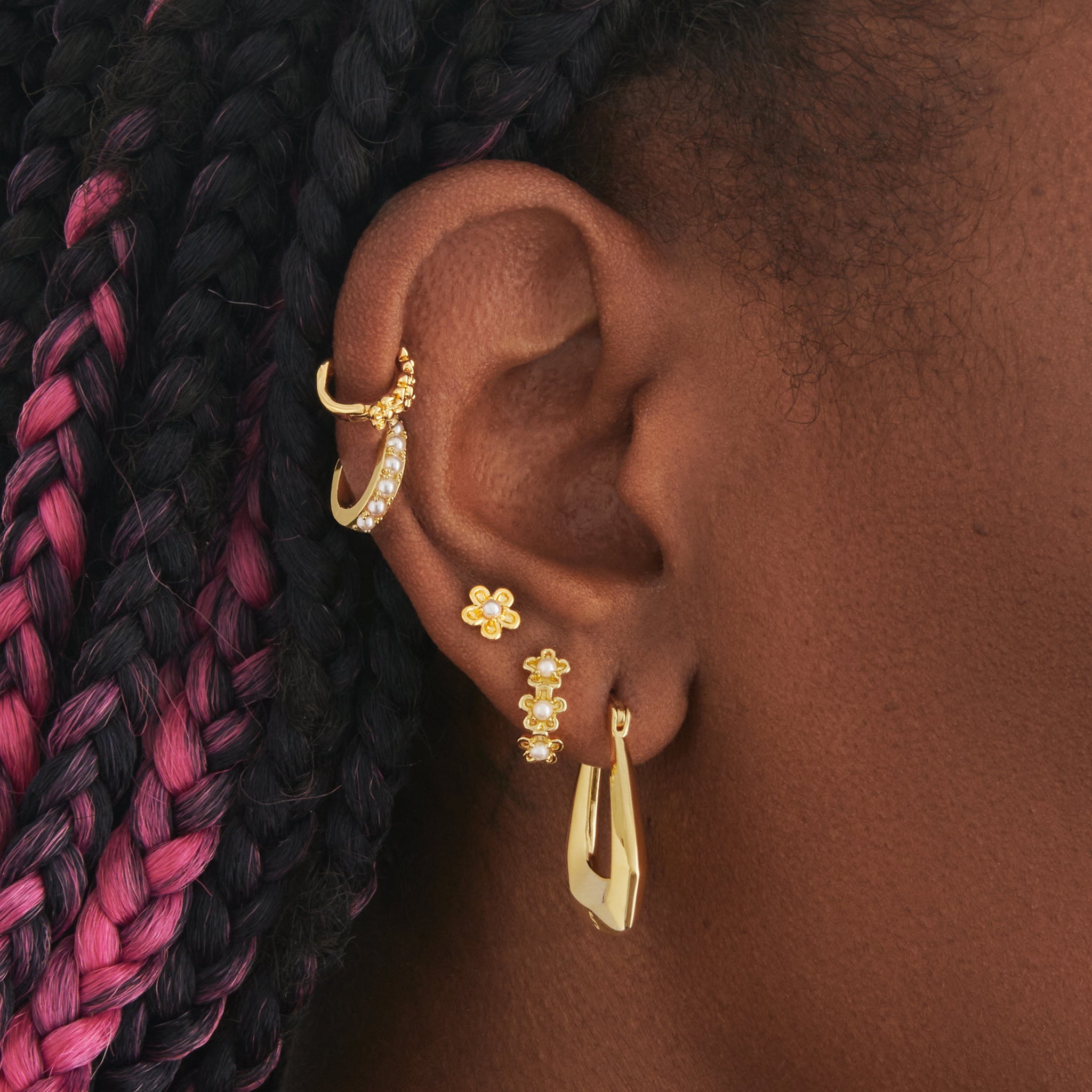 a gold daisy huggie set with pearls on ear [hover] color:null|gold