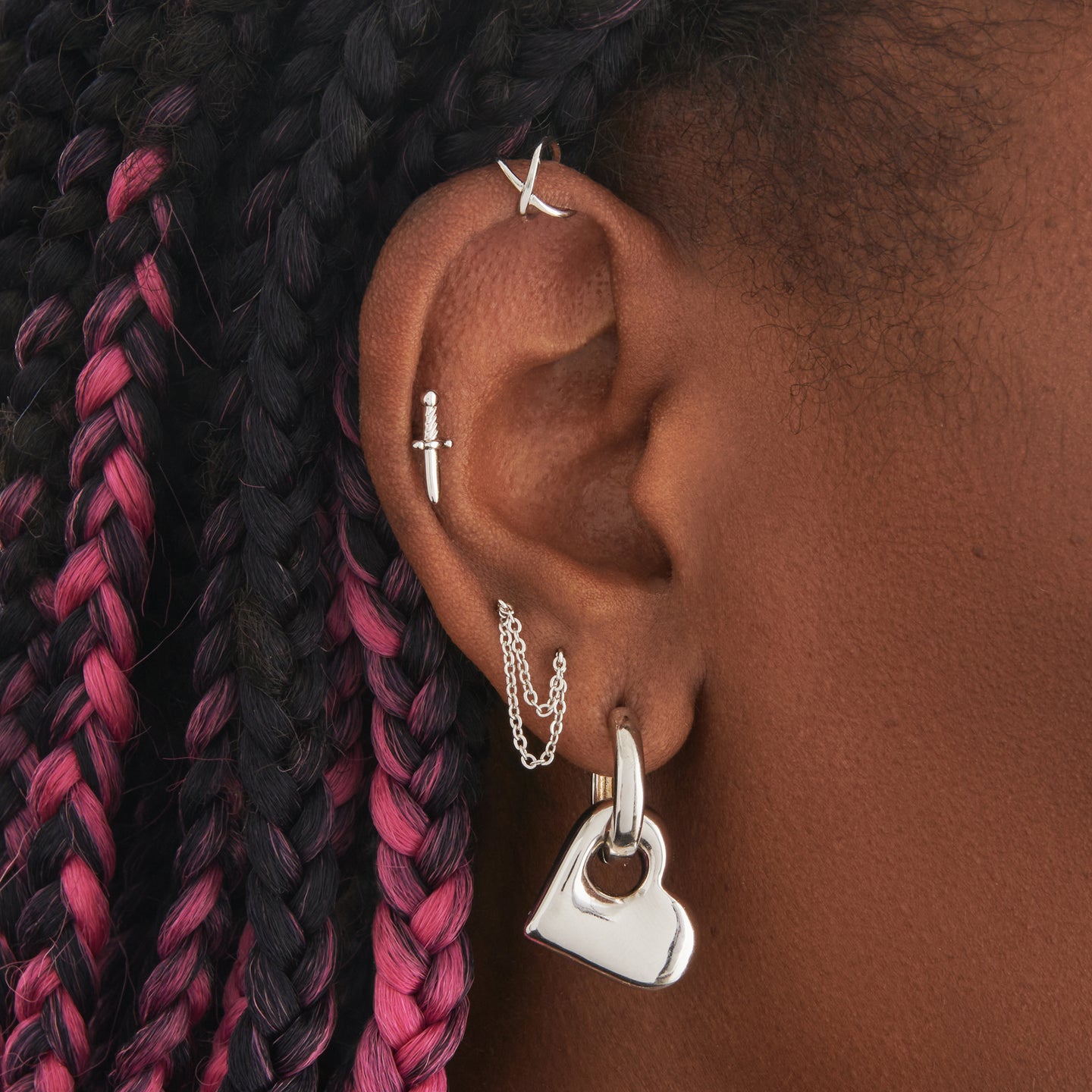 a chunky silver hoop that has a silver puffy heart charm on it on ear [hover] color:null|silver