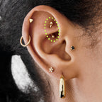 This is an image of a 14K gold curved barbell that is 8mm in length circled on an ear.