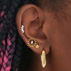 This image is a 14K gold flatback stud with a marquise set crystal cz stone circled on ear.