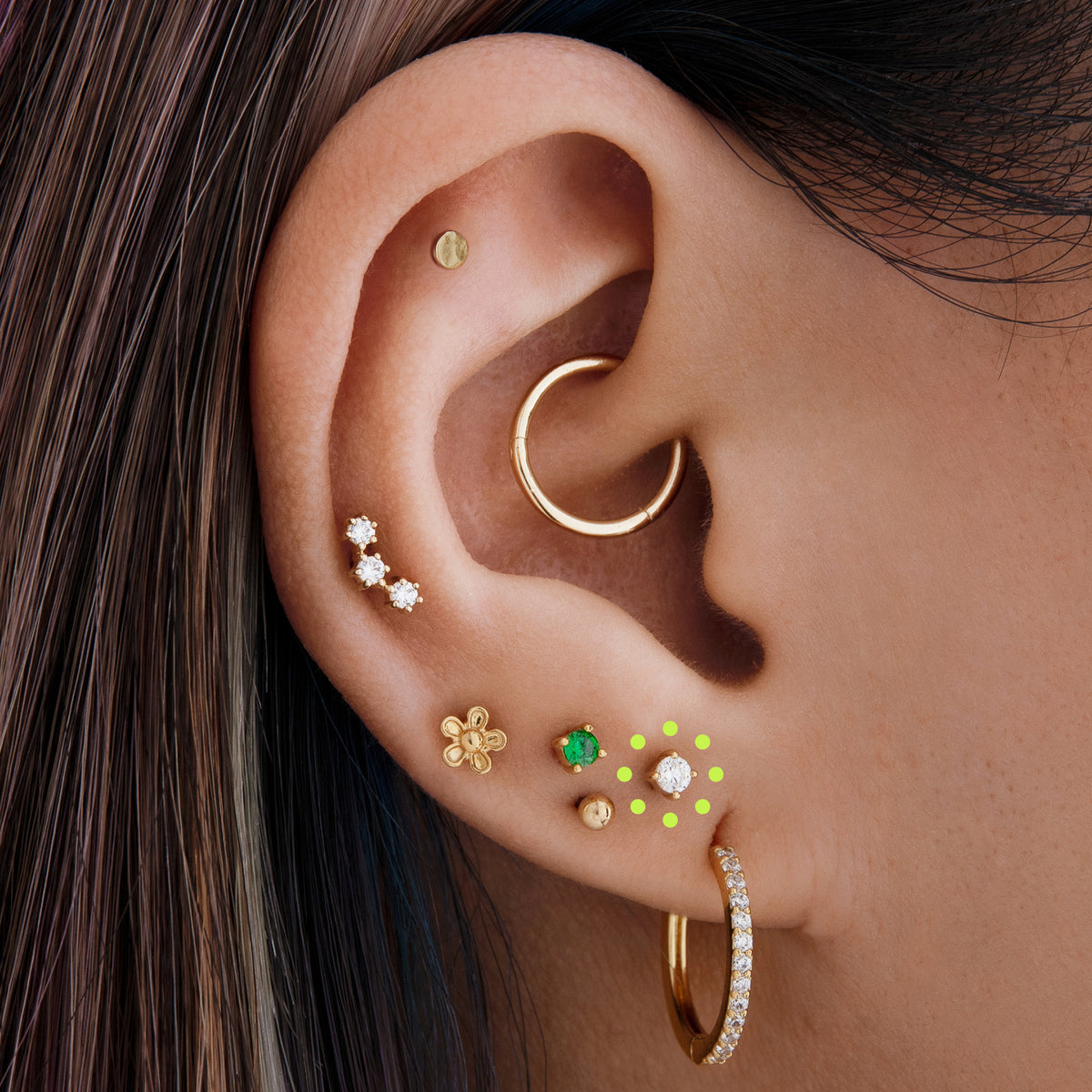 This image is a 14K gold flatback stud with a crystal mini CZ circled on an ear.