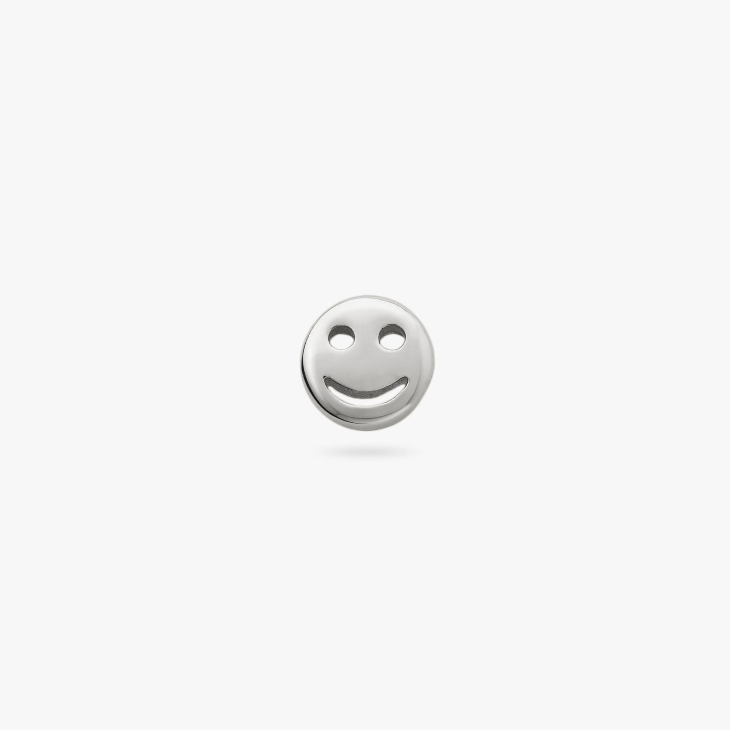 This is a small silver smiley face stud color:null|silver