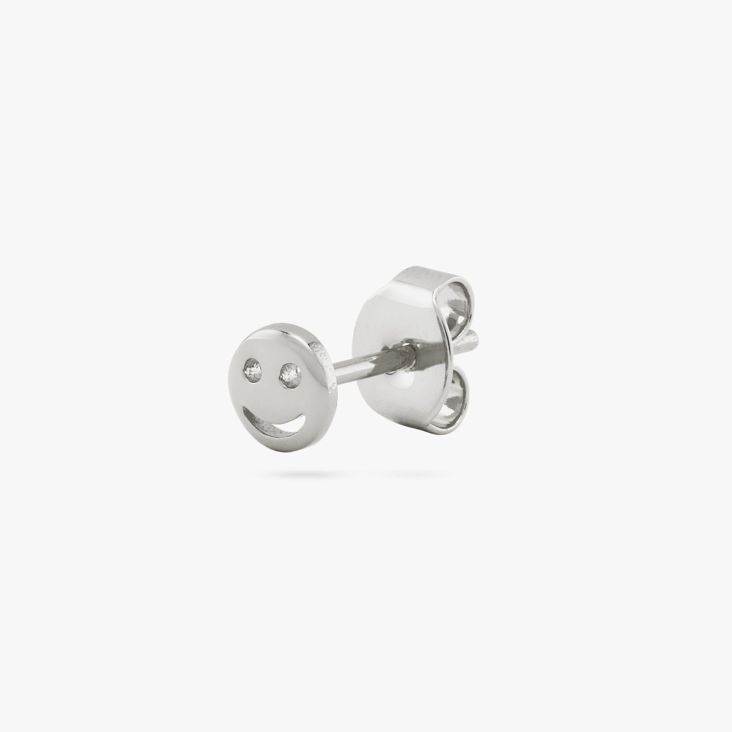 This is a small silver smiley face stud color:null|silver