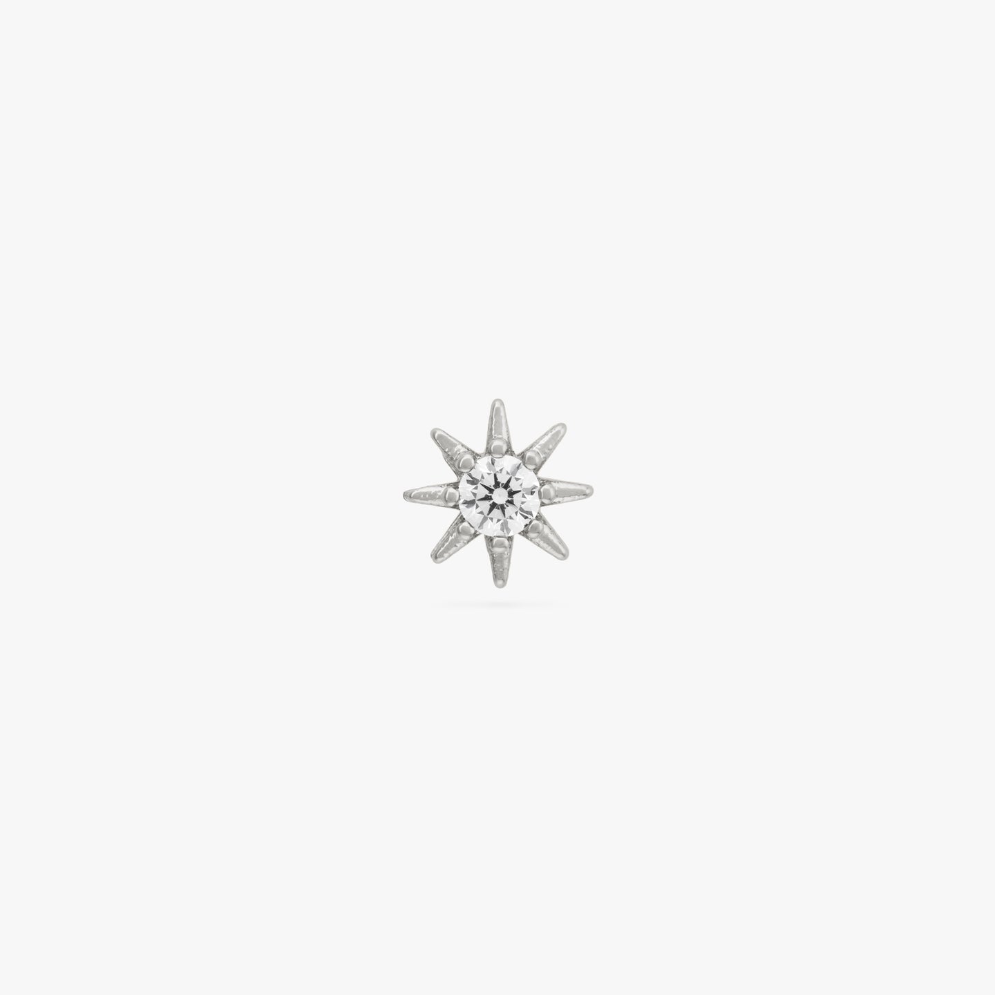 Silver circular shaped stud with very small spikes all around it and CZ gem in the center. color:null|silver/clear