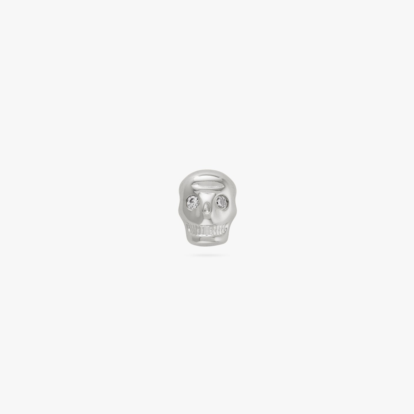 This is a small silver skull stud with cz eyes color:null|silver