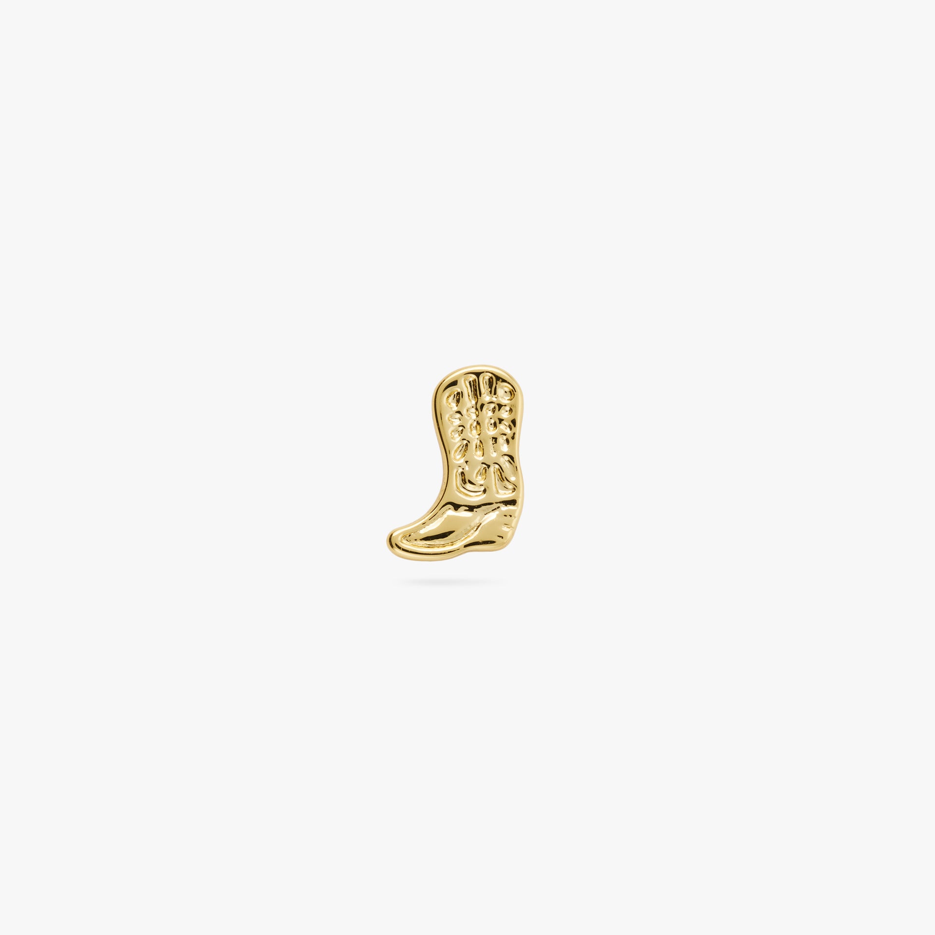 This is a small gold cowboy boot shaped stud with detailing color:null|gold