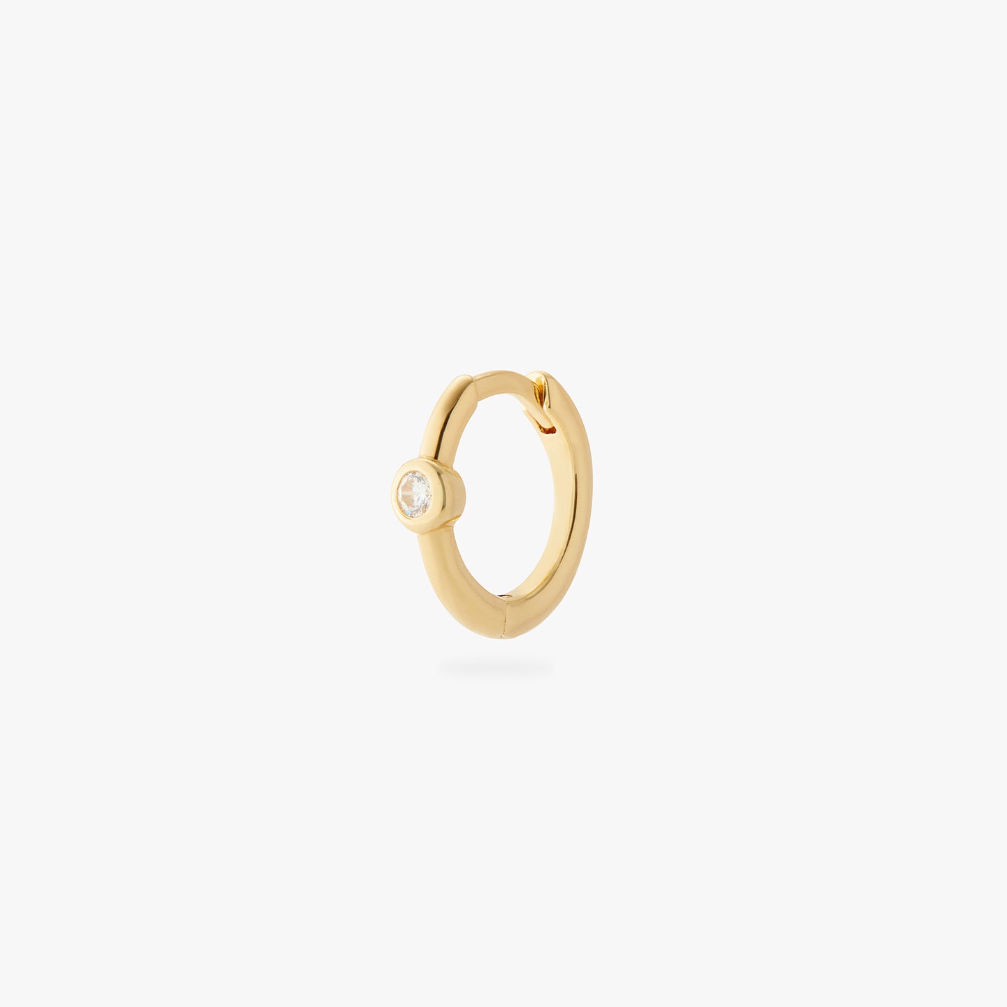 a gold small slim huggie with a clear cz bezel color:null|gold/clear