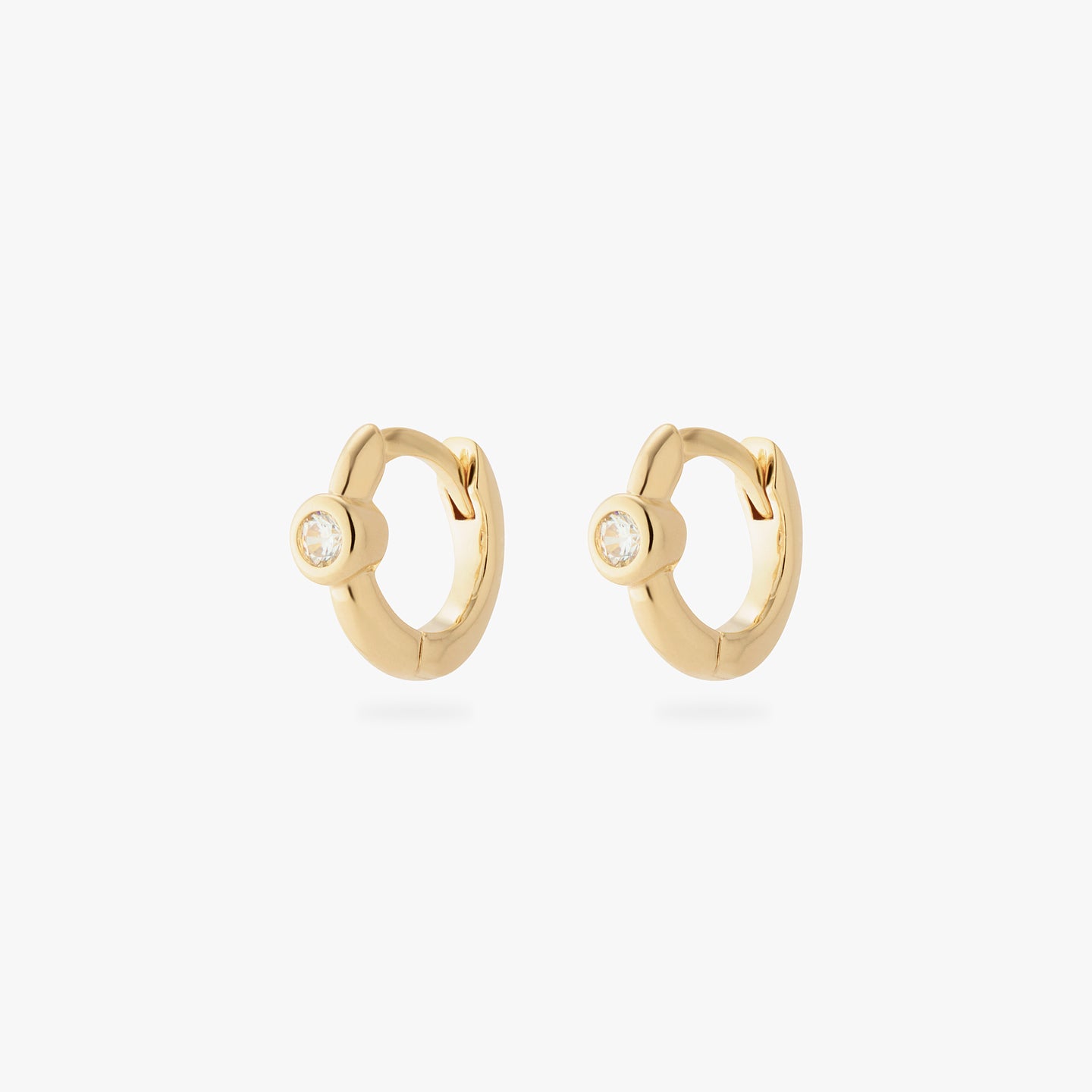 a pair of gold micro helix huggies with a clear bezel [pair] color:null|gold/clear