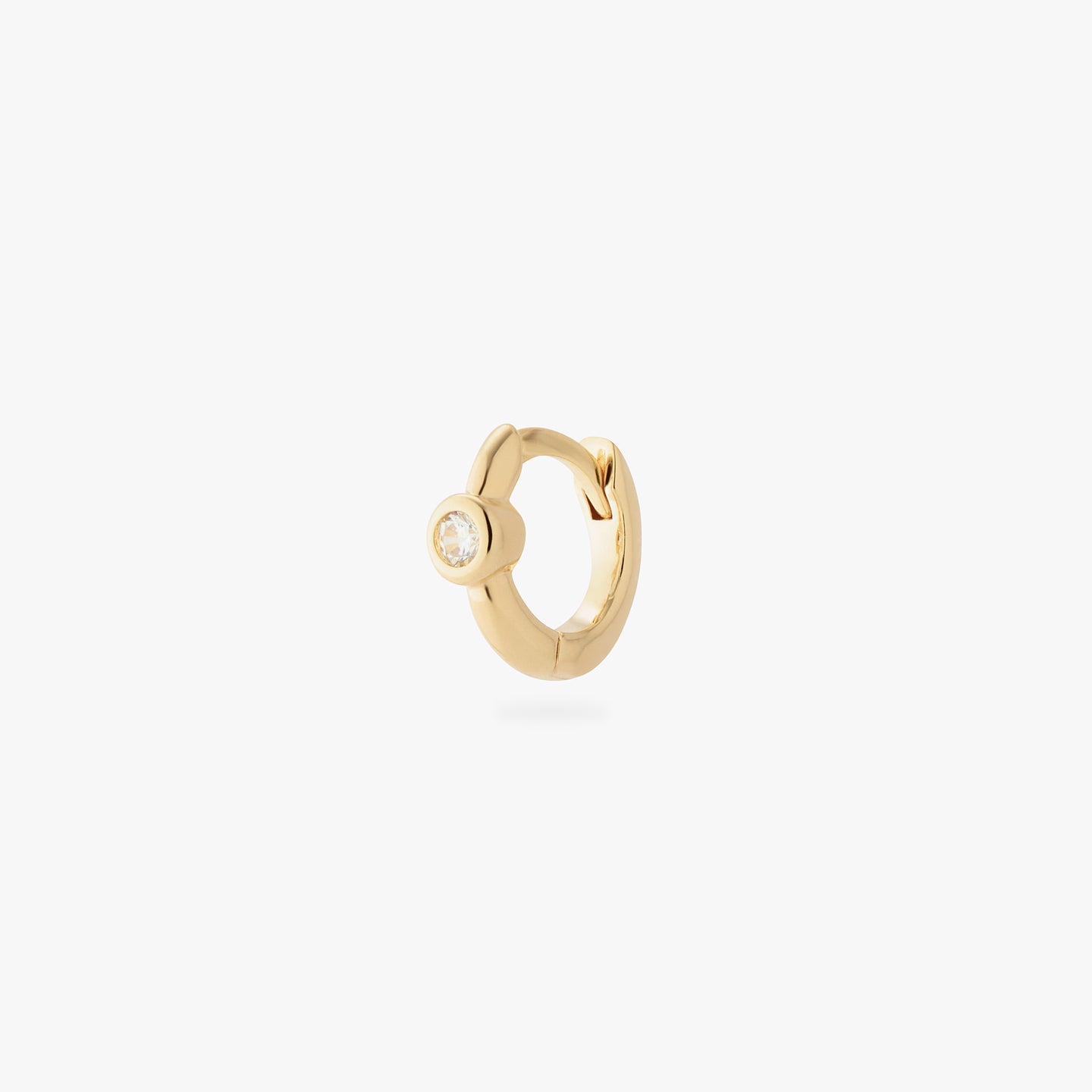 a gold micro helix huggie with a clear bezel color:null|gold/clear