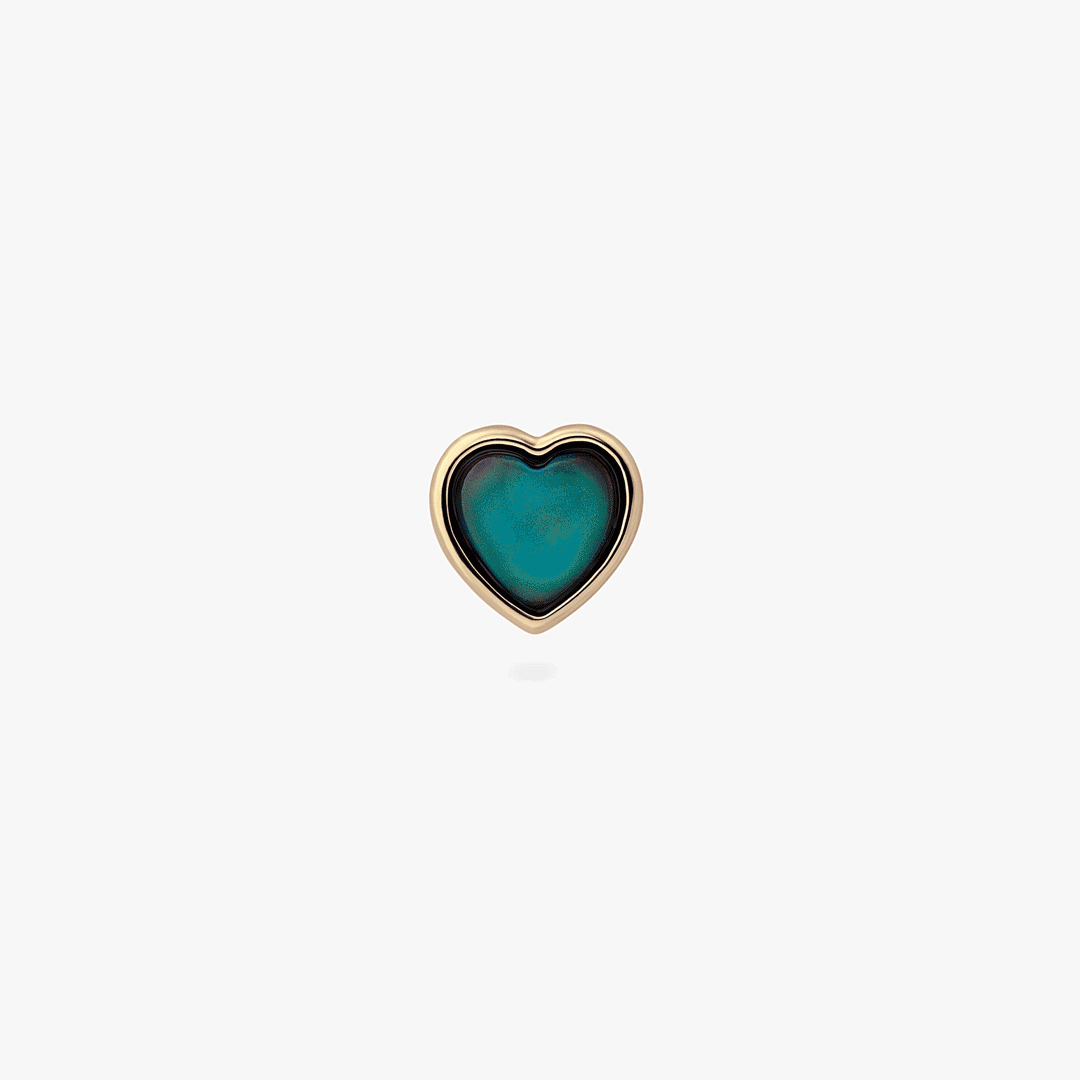 a gold stud in the shape of a heart with a color changing mood stone 