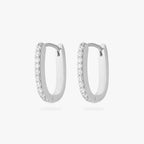 a pair of silver medium oval hoop that have one side pave [pair] color:null|silver/clear